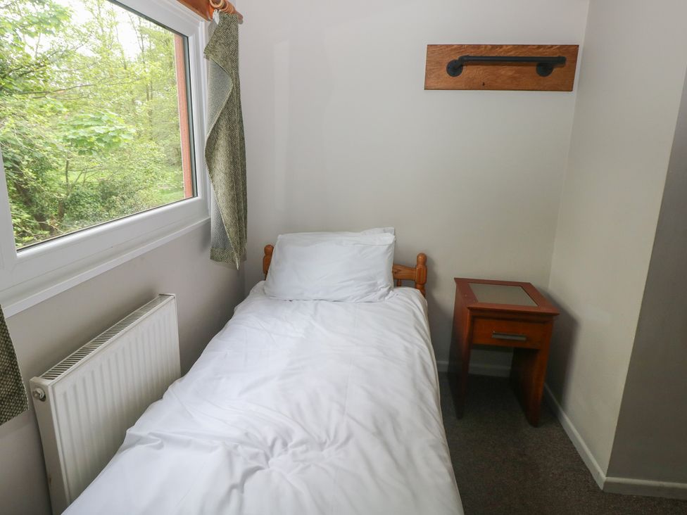 A bedroom with a bed and bedside table at Cabin No. 6 - Salt and Fern Cabins, Goytre near Port Talbot