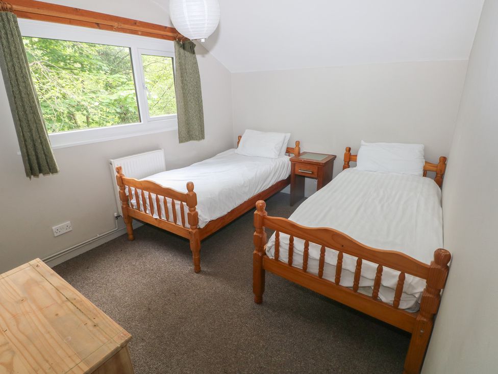 A bedroom with two single beds and a nightstand at Cabin No. 6 - Salt and Fern Cabins Goytre near Port Talbot