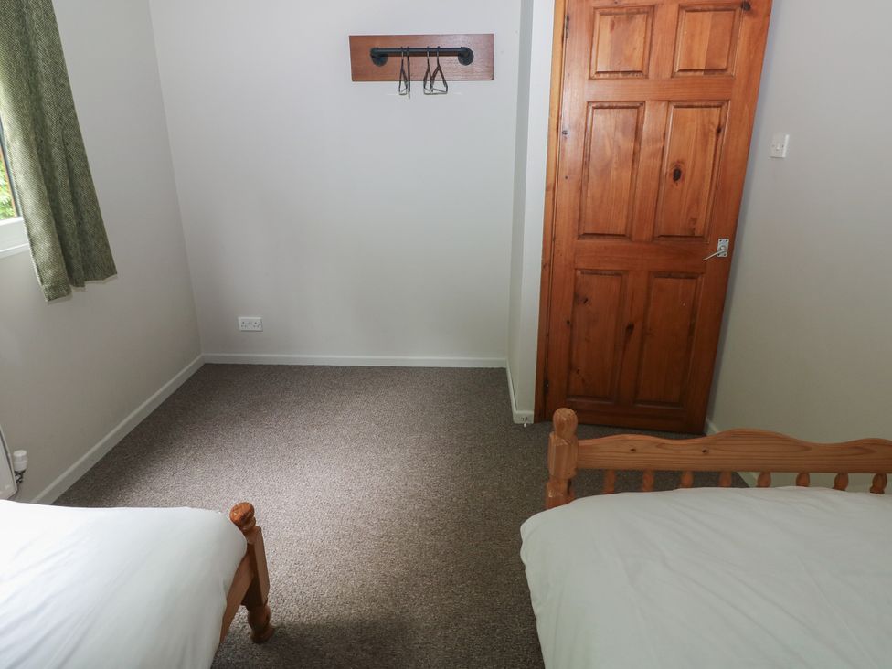 A bedroom with two beds and a door at Cabin No. 6 - Salt and Fern Cabins Goytre near Port Talbot