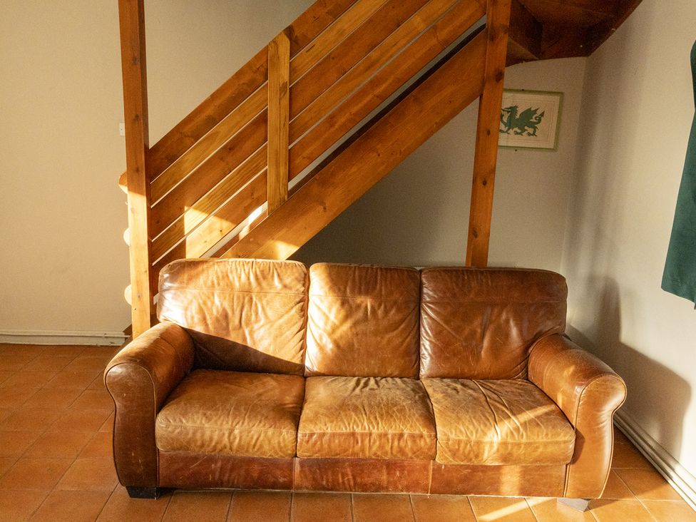 A living room with a couch and staircase at 3 bedroom Cabin (7 of 13) in Port Talbot