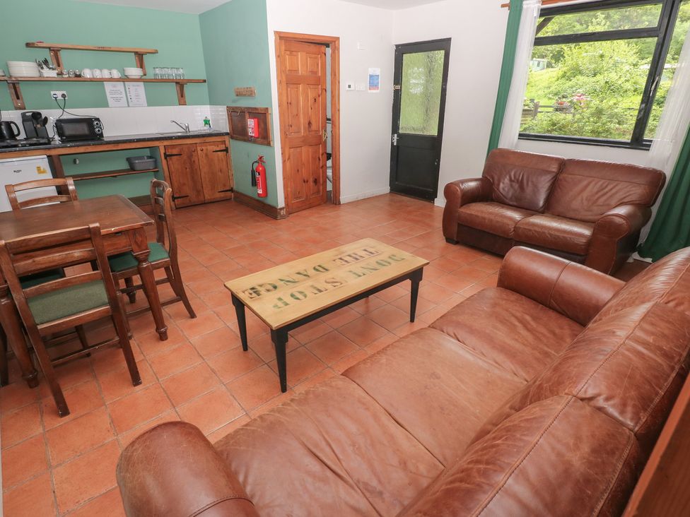 A living room with a table, chairs, and sofa at Cabin No. 7 - Salt and Fern Cabins in Goytre near Port Talbot