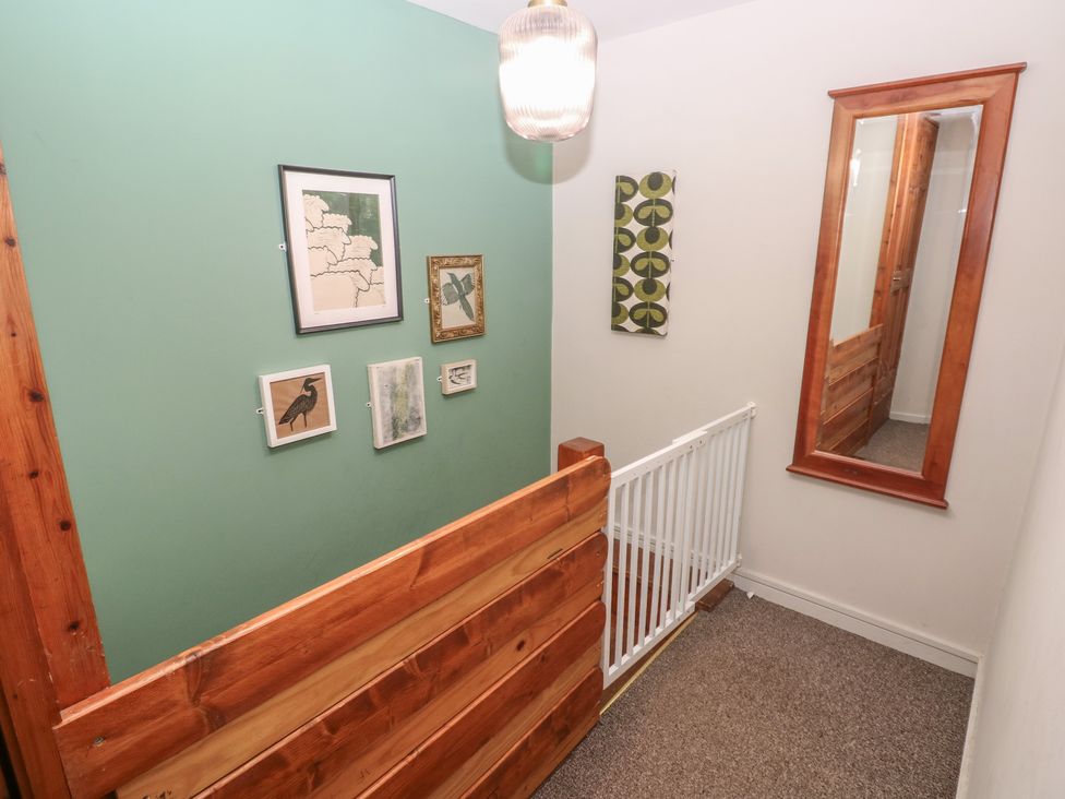 A hallway with wall art and a mirror at Cabin No. 7 - Salt and Fern Cabins in Goytre near Port Talbot