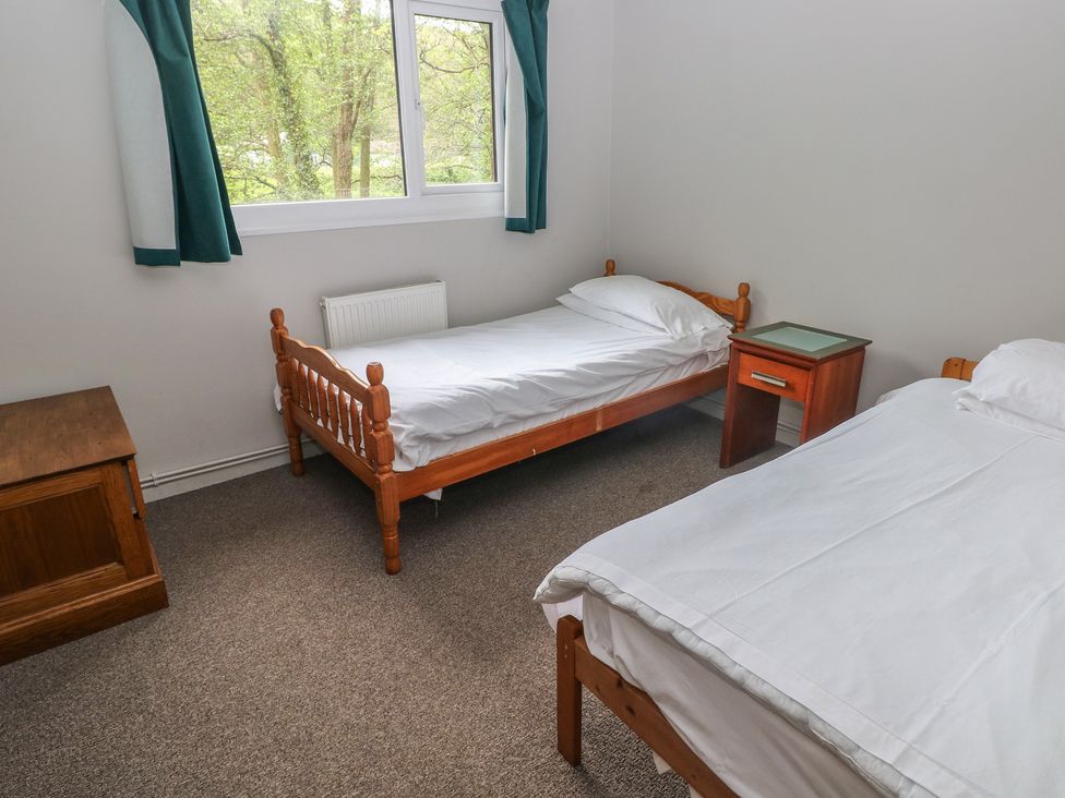 A bedroom with two single beds and a nightstand at Cabin No. 7 - Salt and Fern Cabins Goytre near Port Talbot