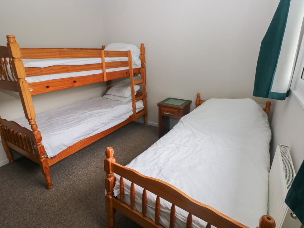 A bedroom with bunk bed and single bed at Cabin No. 8 - Salt and Fern Cabins Goytre near Port Talbot