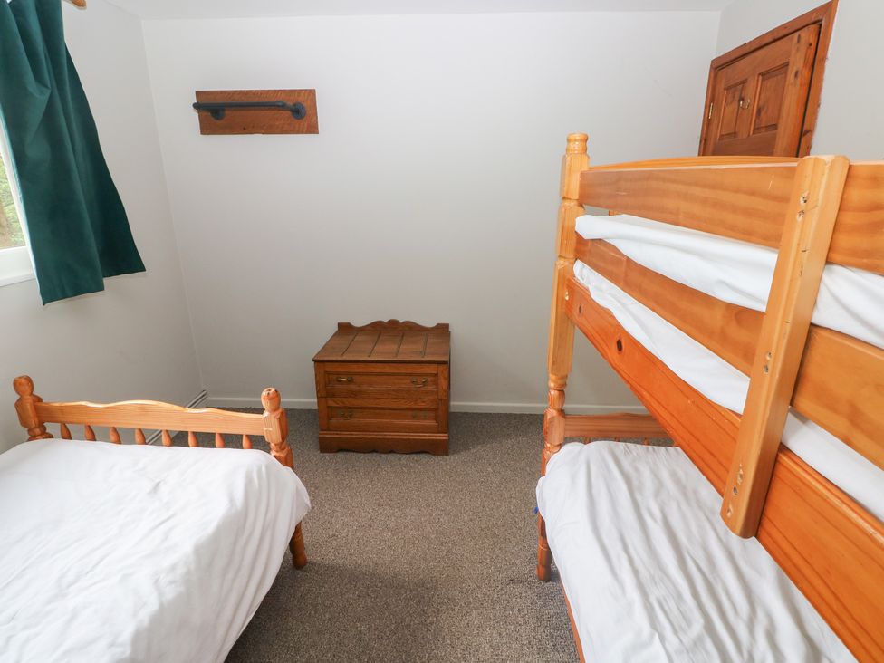 A bedroom with a bunk bed and a single bed at Cabin No. 8 - Salt and Fern Cabins in Goytre near Port Talbot