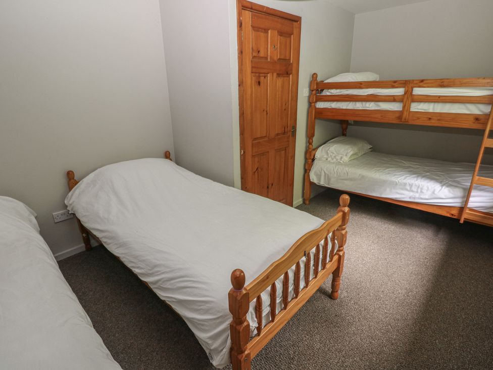 A bedroom with a single bed and a bunk bed at Cabin No. 8 - Salt and Fern Cabins Goytre near Port Talbot