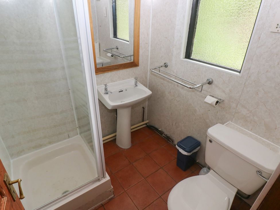 A bathroom with shower, sink, toilet, and mirror at Cabin No. 8 - Salt and Fern Cabins in Goytre near Port Talbot