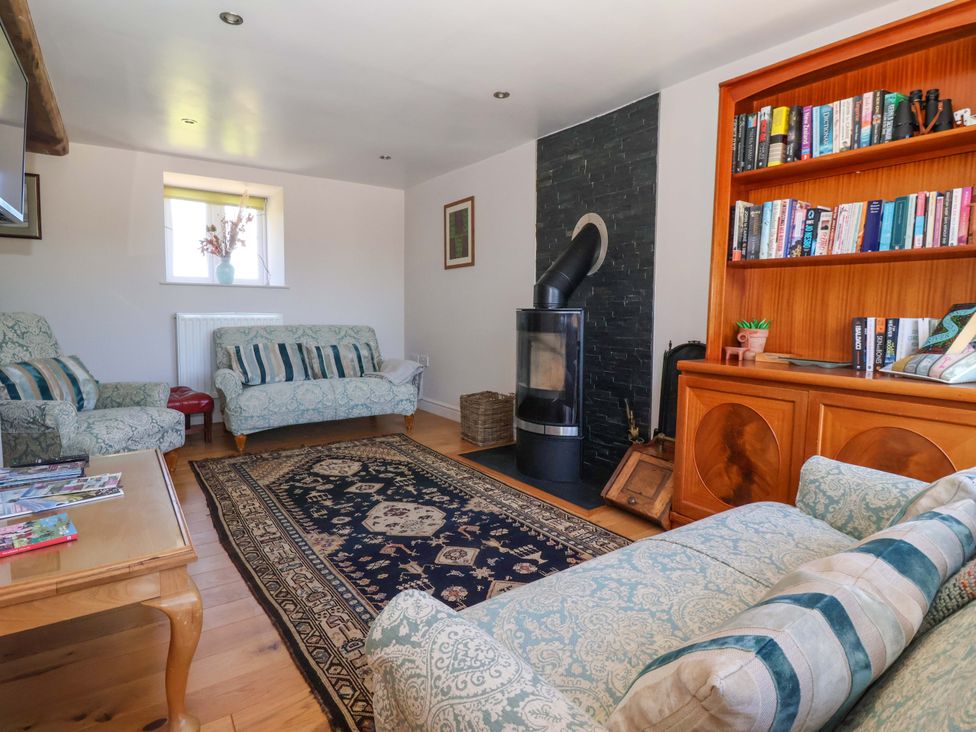 A living room with a stove and bookshelves at The Annexe at Dalby Carr