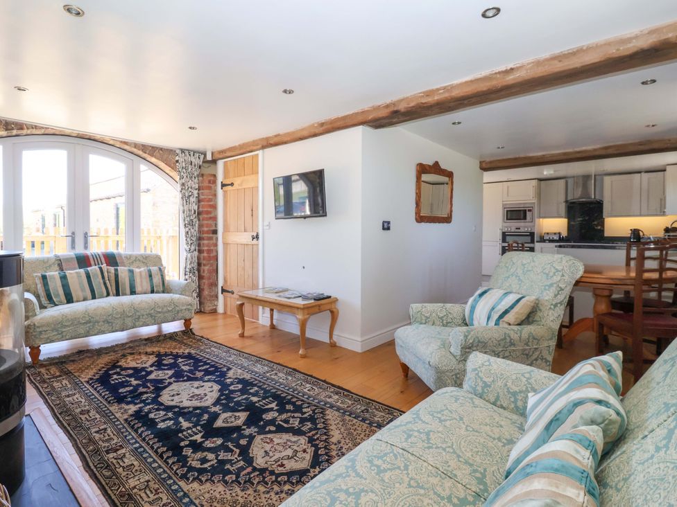 A living room with sofa and dining table at The Annexe at Dalby Carr 