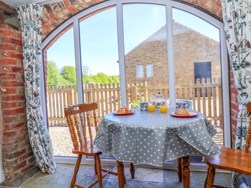A dining area with a table and chairs at The Annexe at Dalby Carr