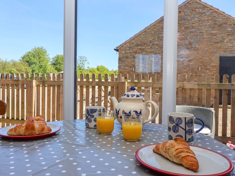 A dining table with croissants and drinks at The Annexe at Dalby Carr