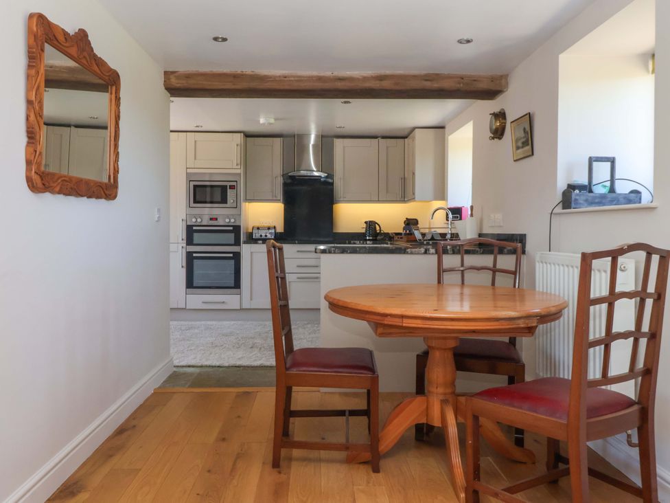 A kitchen with a dining table and chairs at The Annexe at Dalby Carr