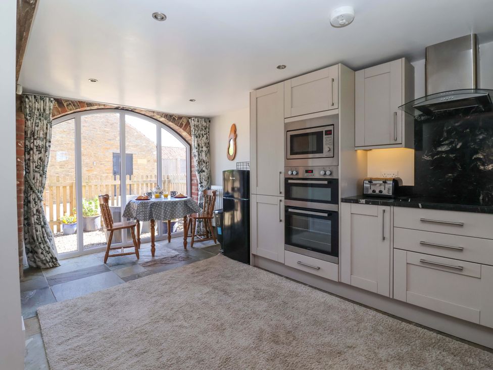 A kitchen with a table and chairs at The Annexe at Dalby Carr