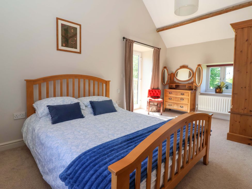 A bedroom with a bed and dresser at The Annexe at Dalby Carr