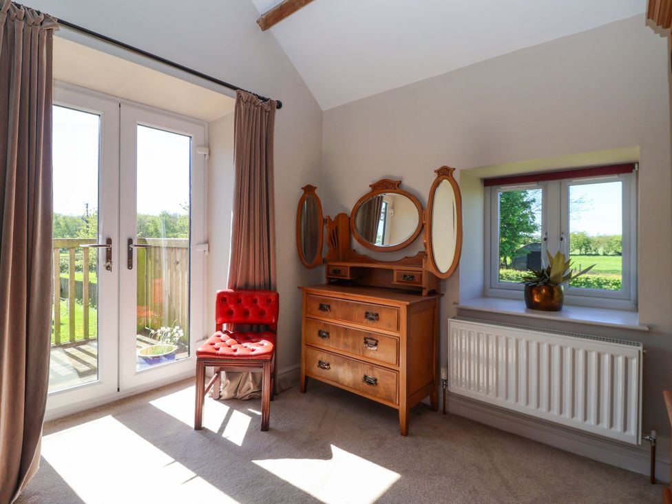 A bedroom with a dressing table and chair at The Annexe at Dalby Carr