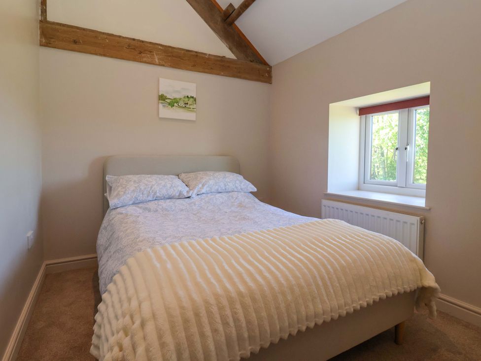 A bedroom with a bed and a window at The Annexe at Dalby Carr