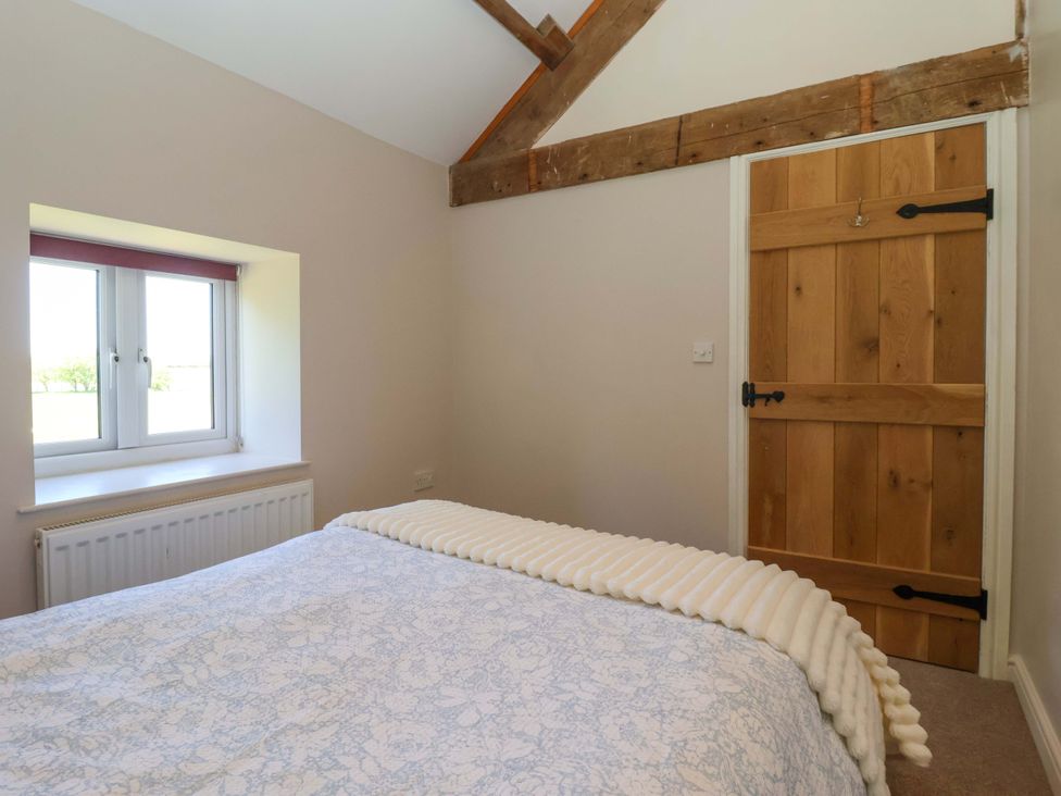 A bedroom with a bed and window at The Annexe at Dalby Carr