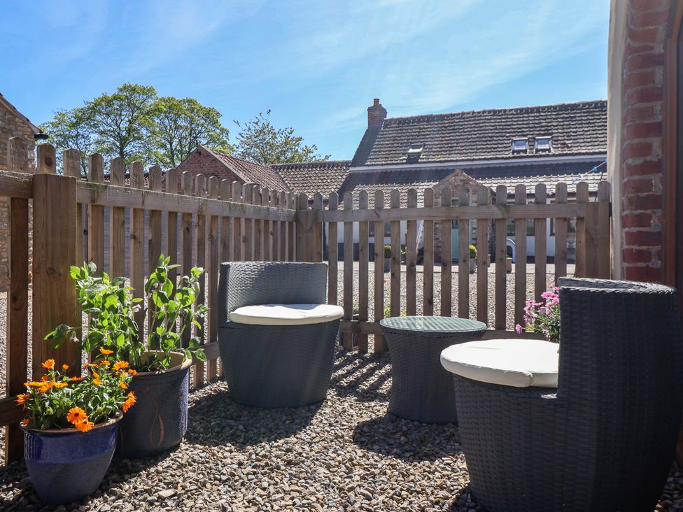 An outdoor seating area with chairs and plants at The Annexe at Dalby Carr