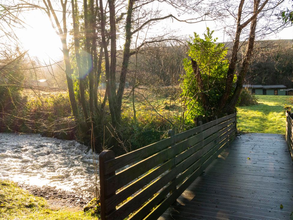 A bridge over a stream with trees and buildings at 3 Bedroom Cabin (9 of 13) Port Talbot