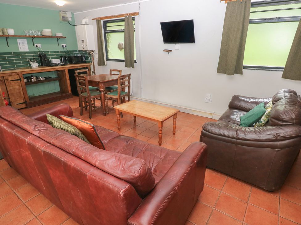 A living room with sofas and a kitchenette at Cabin No. 9 - Salt and Fern Cabins Goytre near Port Talbot