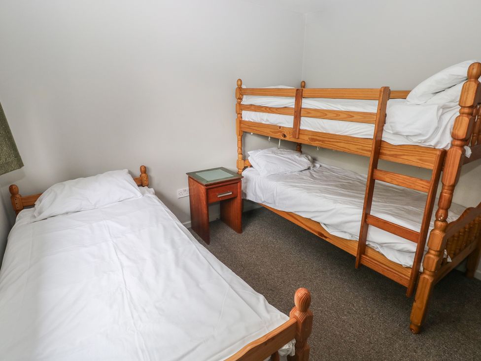 A bedroom with a single bed and a bunk bed at Cabin No. 9 - Salt and Fern Cabins in Goytre near Port Talbot