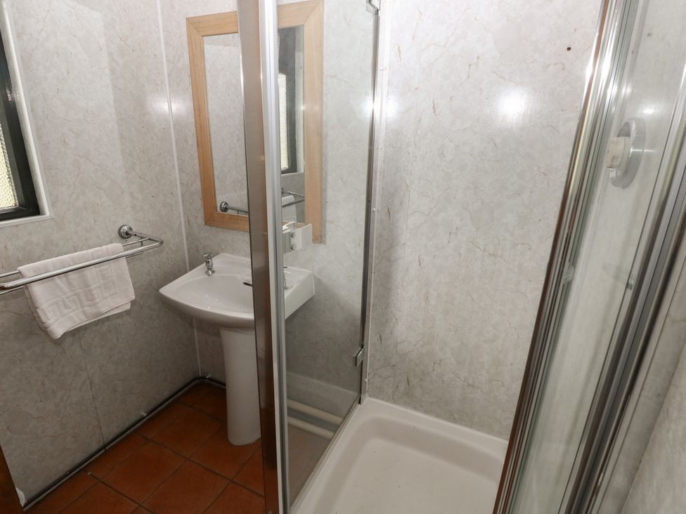 A bathroom with a shower and sink at Cabin No. 9 - Salt and Fern Cabins Goytre near Port Talbot
