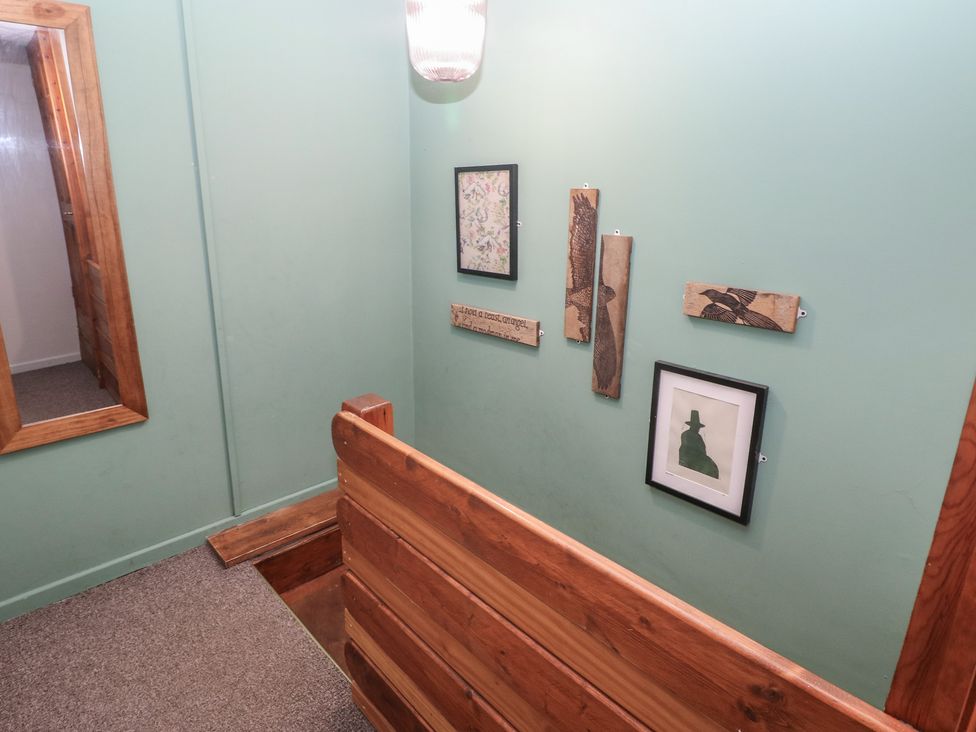 A hallway with wall art and a mirror at Cabin No. 10 - Salt and Fern Cabins Goytre near Port Talbot