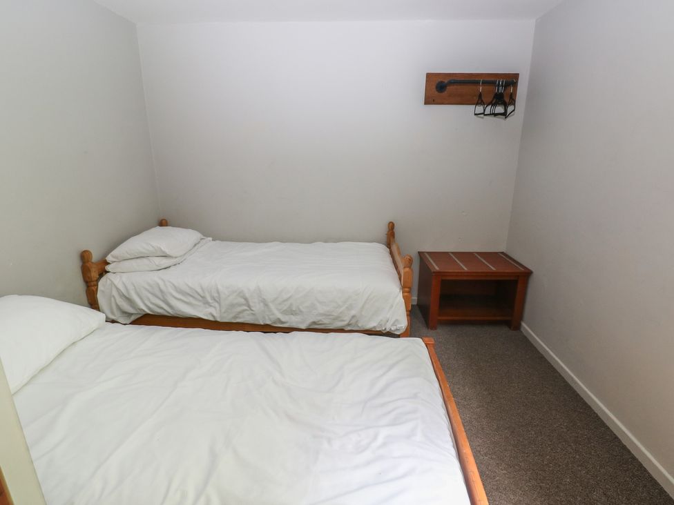A bedroom with two twin beds and a table at Cabin No. 10 - Salt and Fern Cabins in Goytre near Port Talbot