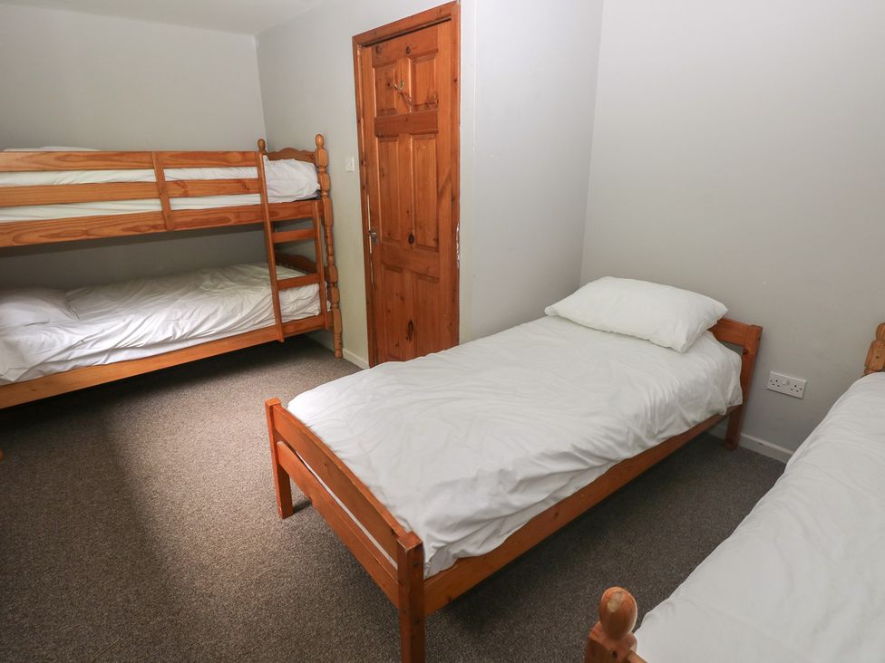 A bedroom with bunk beds and single beds at Cabin No. 10 - Salt and Fern Cabins in Goytre near Port Talbot