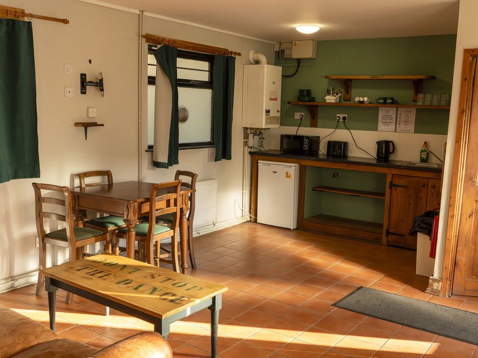 A kitchen with table and chairs at 3 Bedroom Cabin (11 of 13) Port Talbot