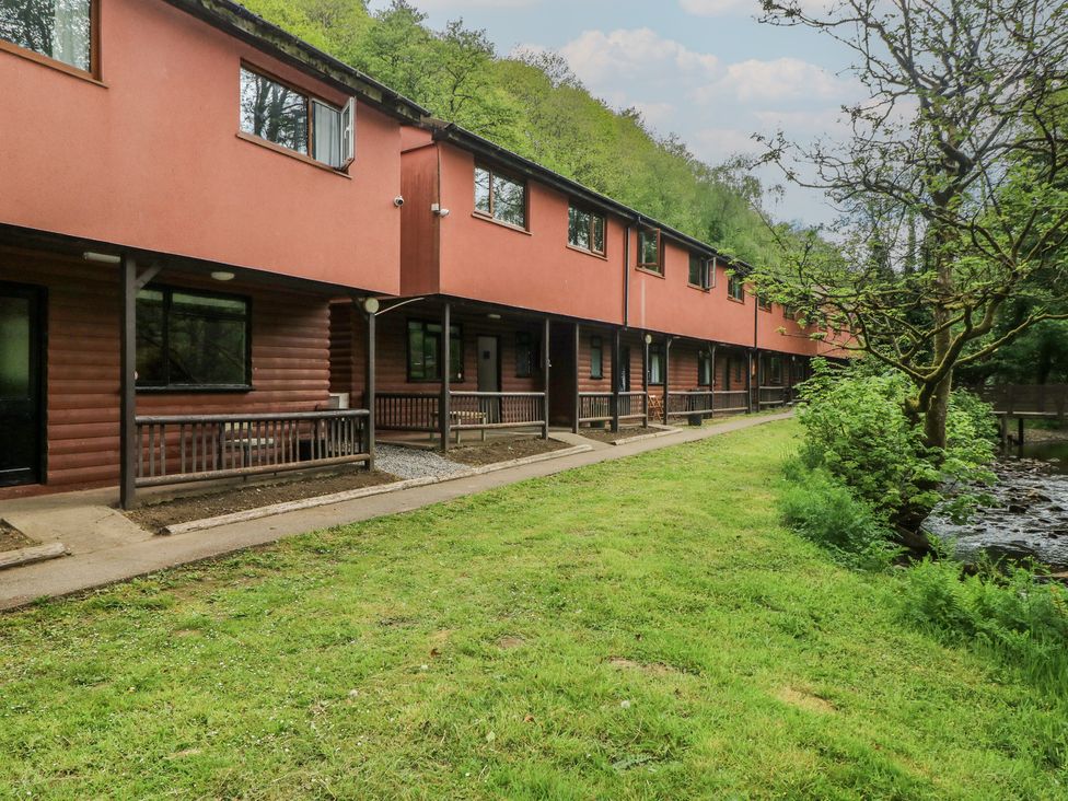 A row of cottages with grassy area at Cabin No. 11 - Salt and Fern Cabins in Goytre near Port Talbot