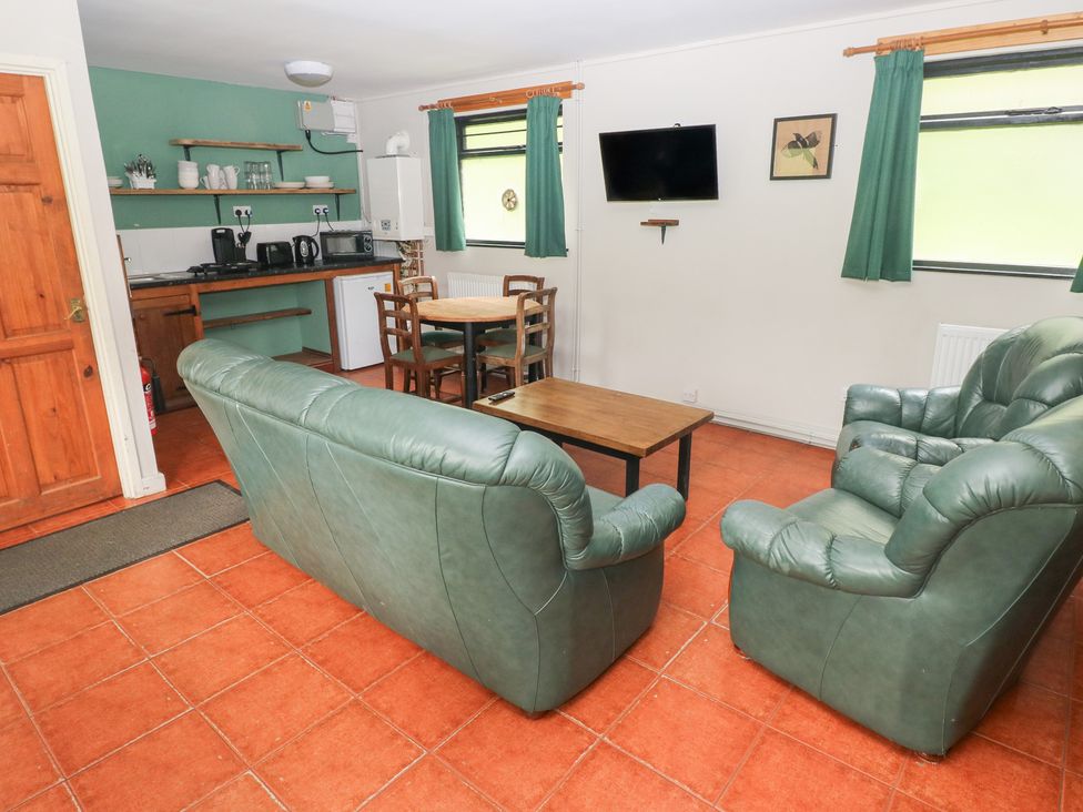 A living room with sofa and dining table at Cabin No. 11 - Salt and Fern Cabins near Goytre near Port Talbot