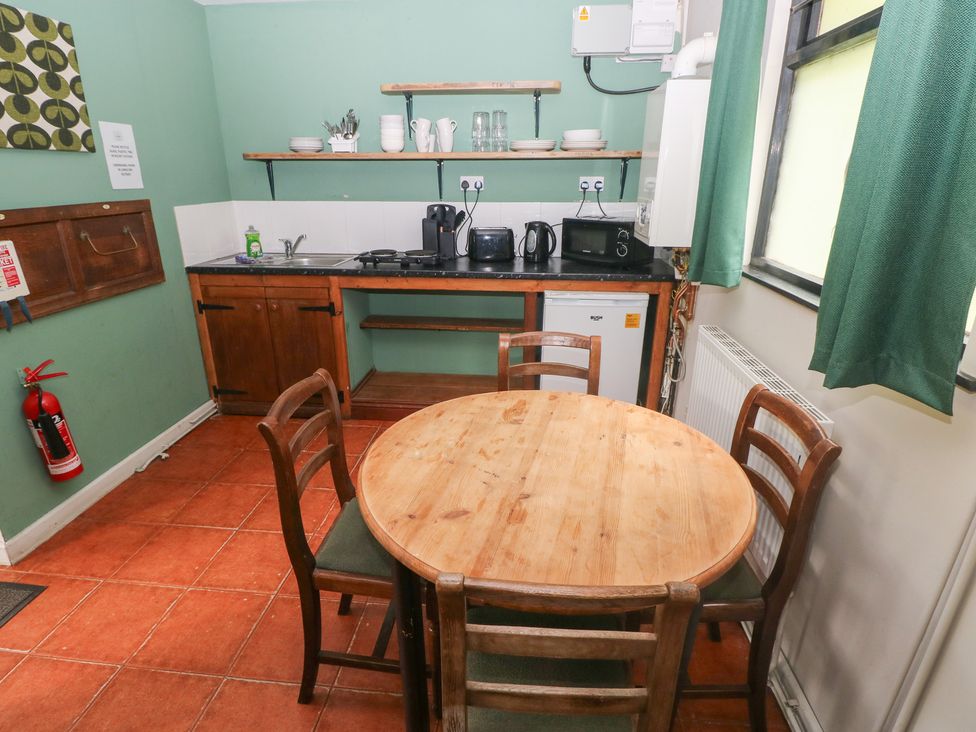 A kitchen with a wooden table and chairs at Cabin No. 11 - Salt and Fern Cabins Goytre near Port Talbot