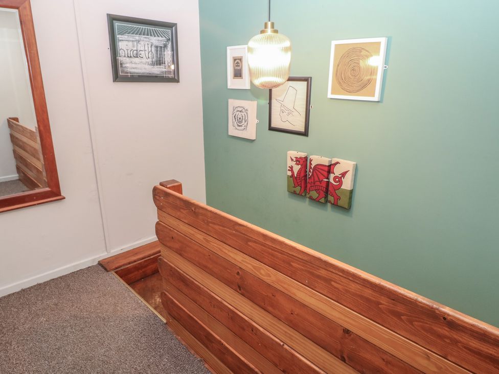A hallway with wooden paneling and wall art at Cabin No. 11 - Salt and Fern Cabins in Goytre near Port Talbot