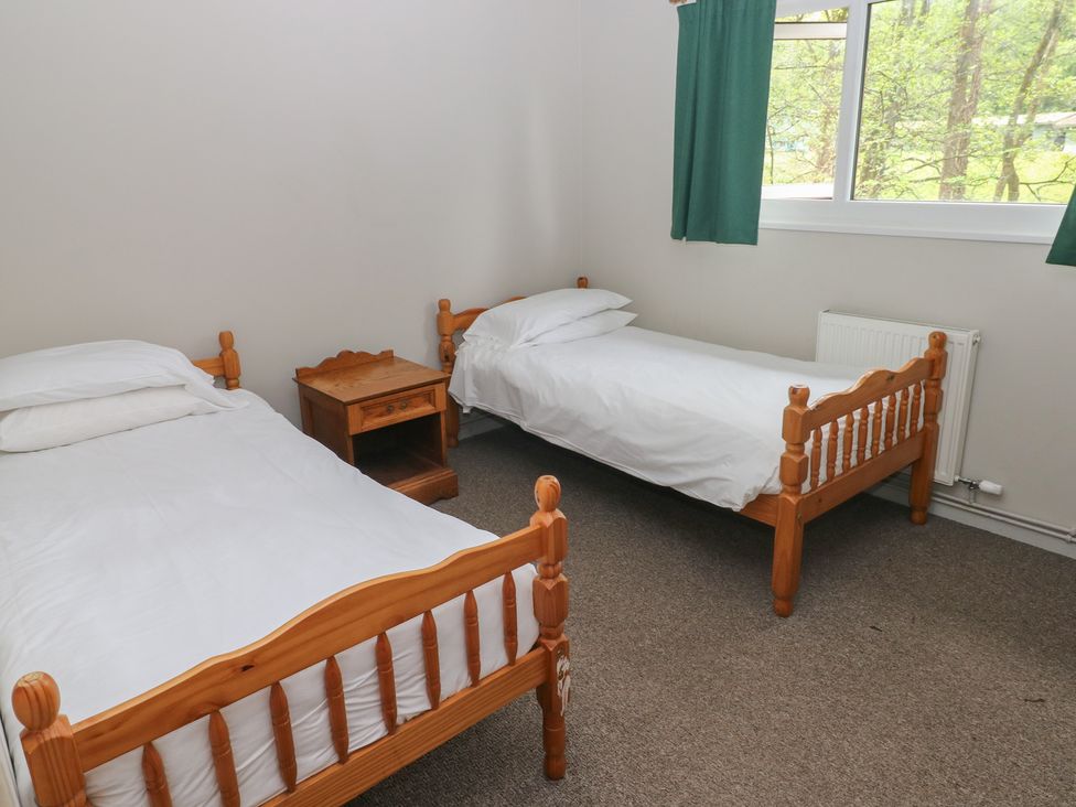 A bedroom with two beds and a nightstand at Cabin No. 11 - Salt and Fern Cabins Goytre near Port Talbot