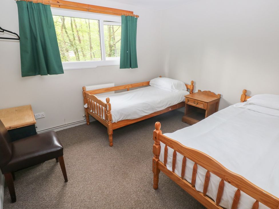 A bedroom with two beds and a nightstand at Cabin No. 11 - Salt and Fern Cabins Goytre near Port Talbot