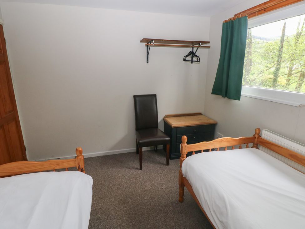 A bedroom with two beds and a chair at Cabin No. 11 - Salt and Fern Cabins Goytre near Port Talbot