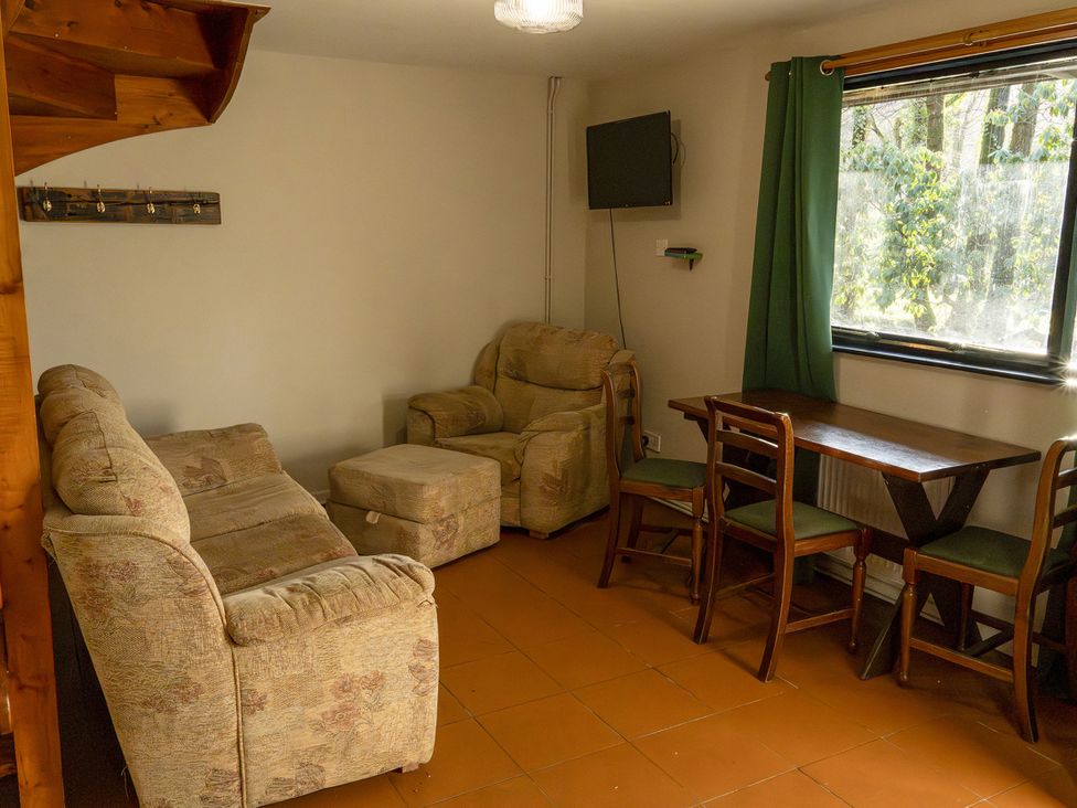 A living room with a sofa and dining table at 3 bedroom Cabin (12 of 13)