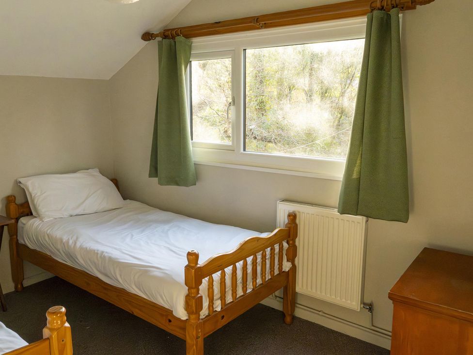 A bedroom with beds and a window at 3 bedroom Cabin (12 of 13)