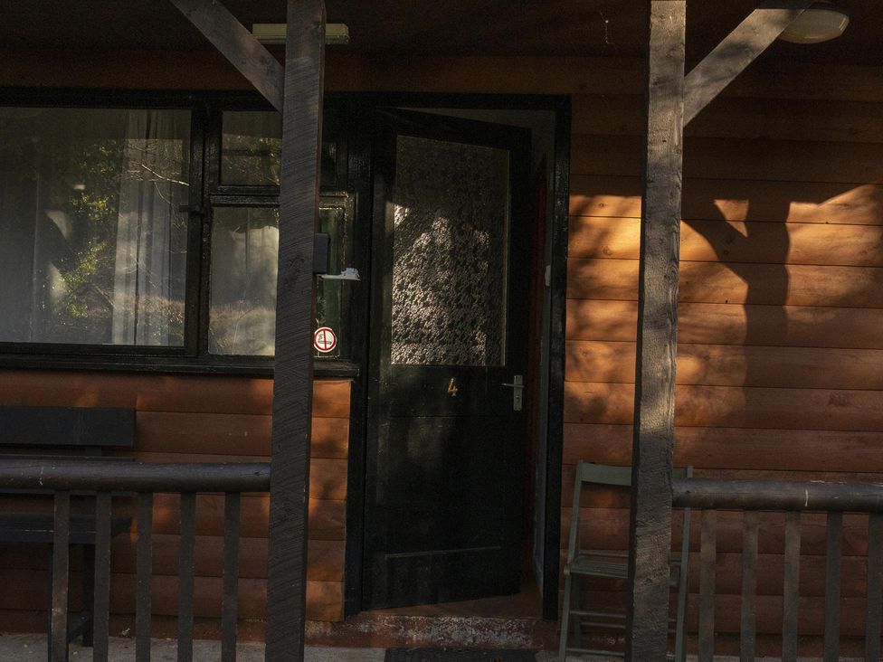 A door with windows and a chair on a porch at 3 bedroom Cabin (12 of 13)