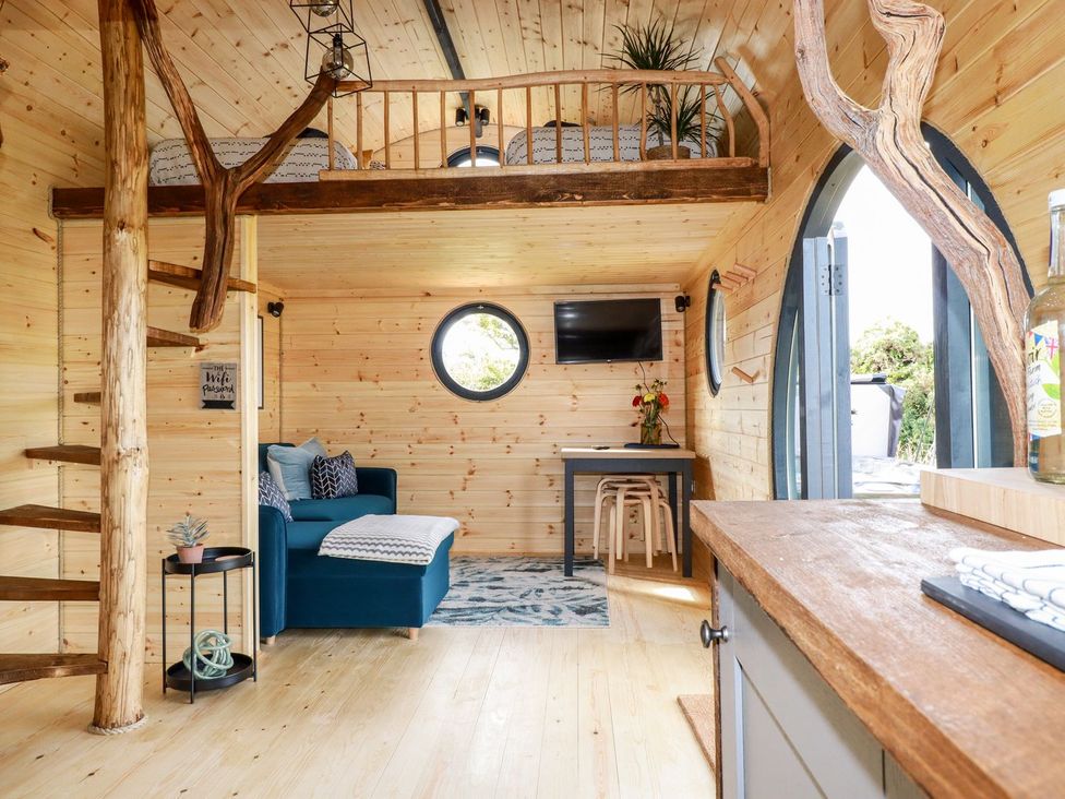 A living room with a sofa and a staircase at The Olju in Truro