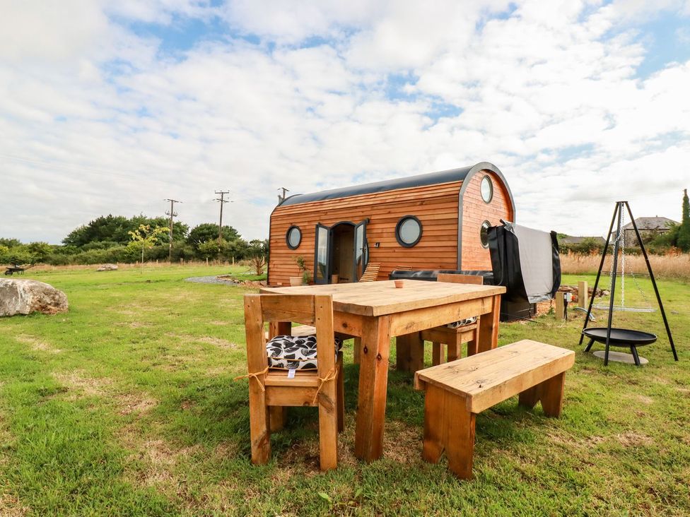 An outdoor seating area with a wooden table and bench at The Olju in Truro