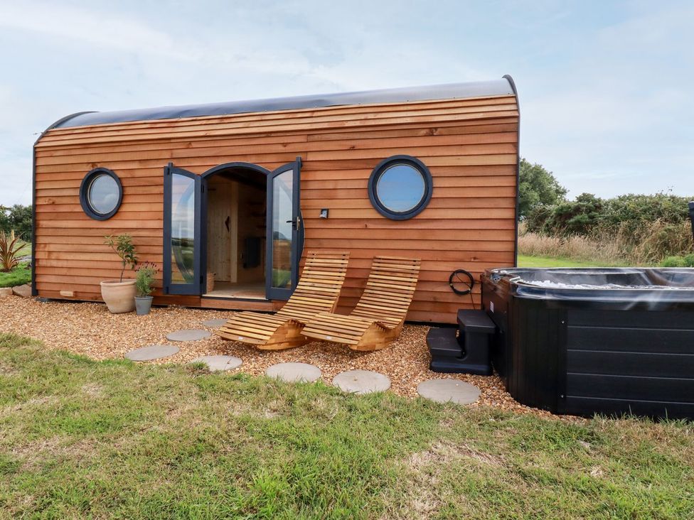 A house with a hot tub and chairs in the outdoor area at The Olju in Truro
