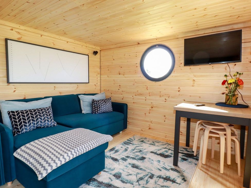 A living room with a sofa and table at The Olju in Truro