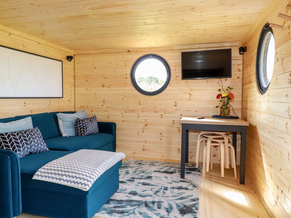 A living room with a sofa and a table at The Olju in Truro