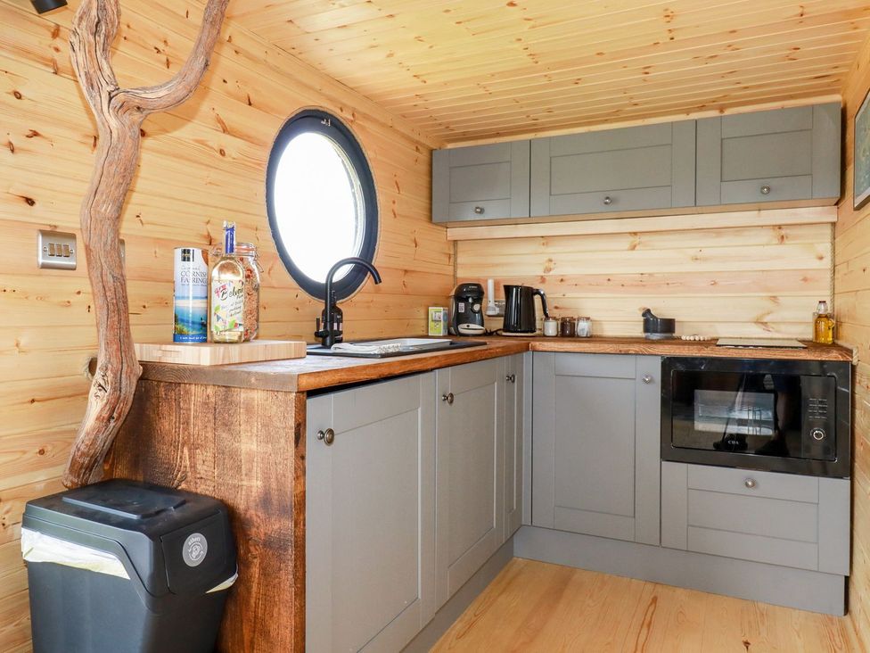 A kitchen with cabinets and appliances at The Olju in Truro