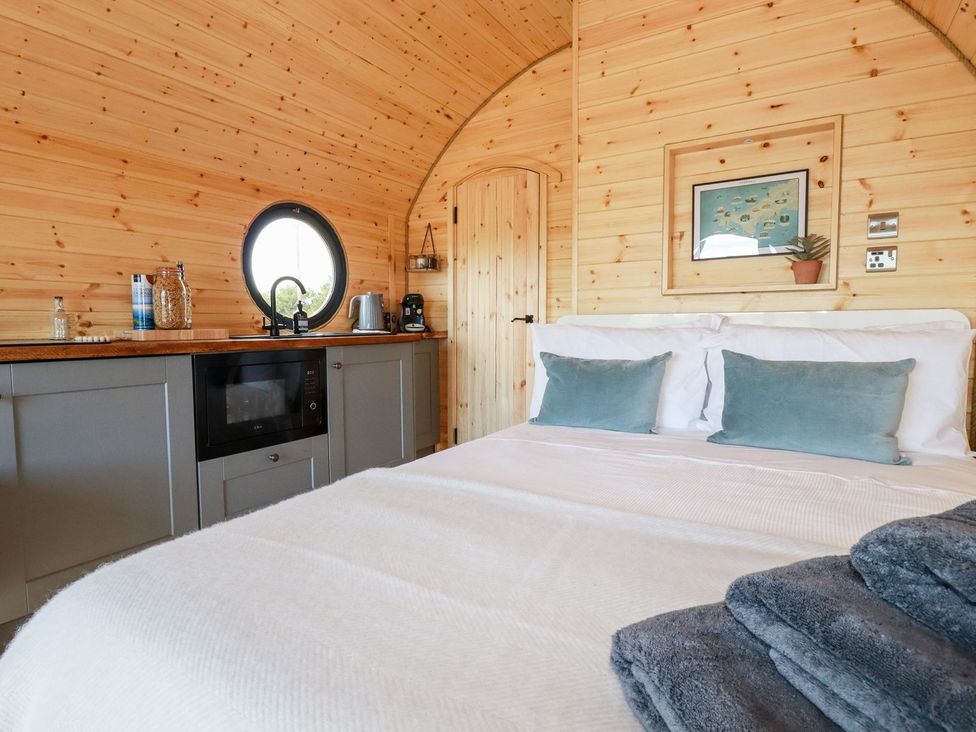 A bedroom with a bed and kitchenette at Stargaze in Truro