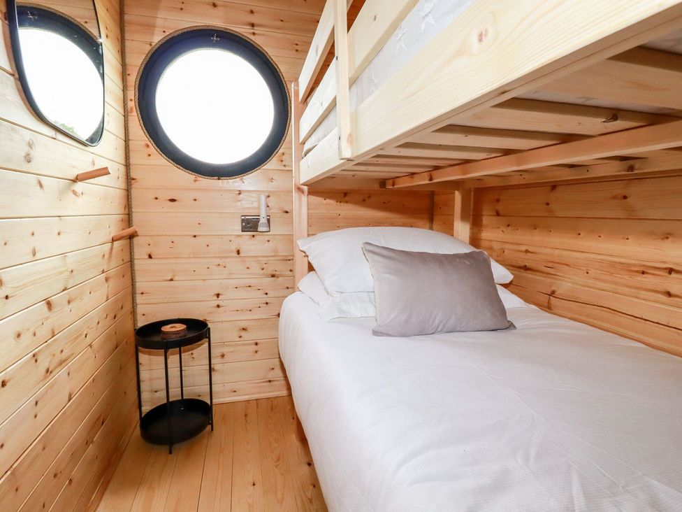 A bedroom featuring a bunk bed and round window at Stargaze in Truro