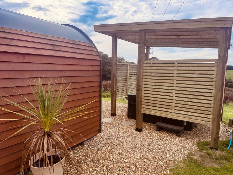 An outdoor area with a wooden structure, gravel path, and a planter at Stargaze in Truro