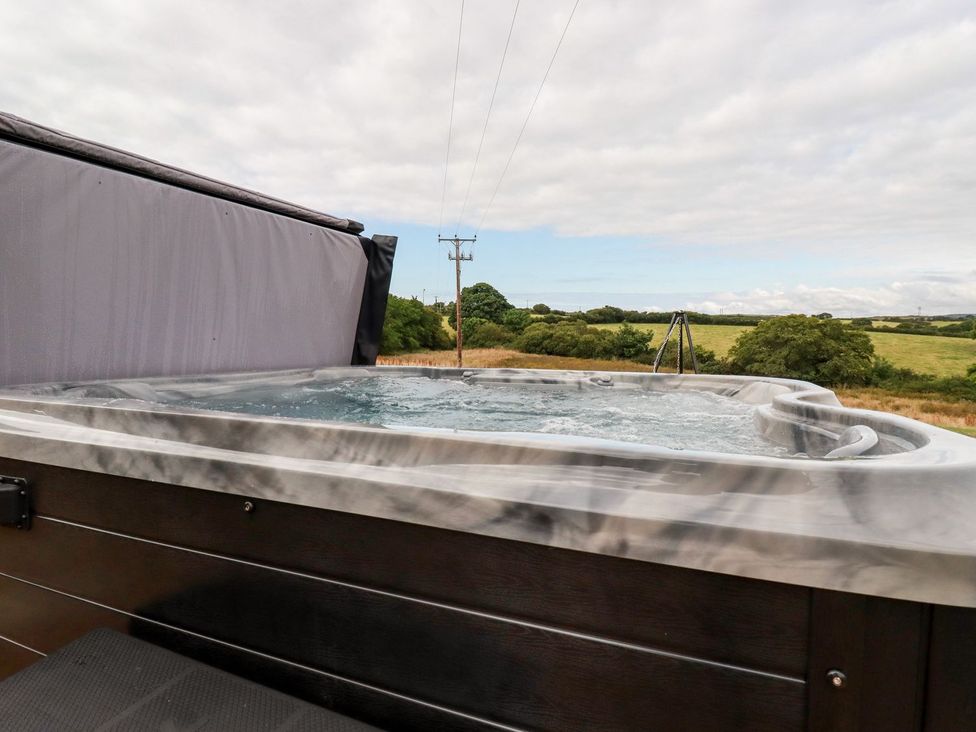 A hot tub with a view of grass and trees at Stargaze in Truro